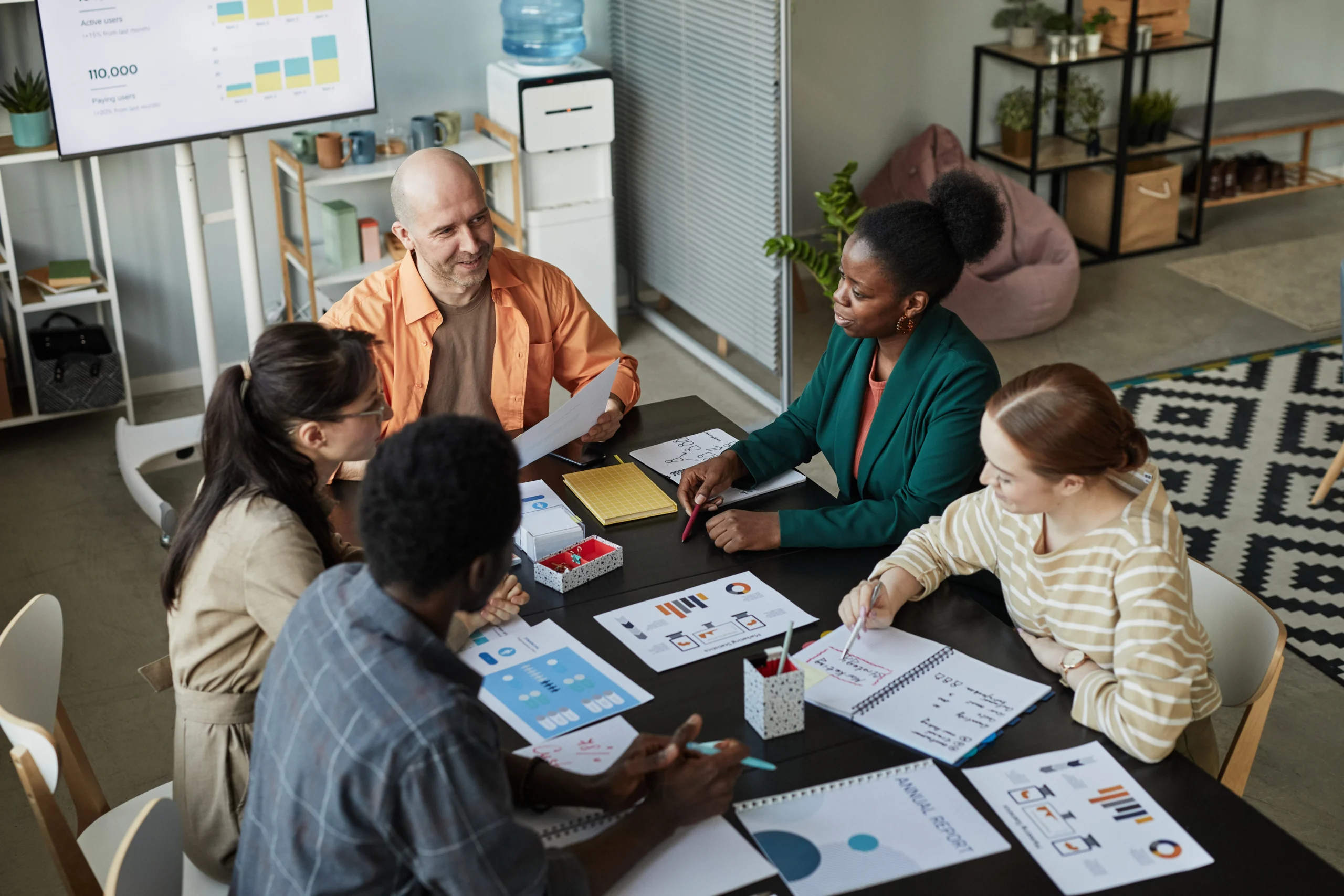 Group of professionals having a collaborative meeting, discussing data strategies and business use cases for Microsoft Fabric.