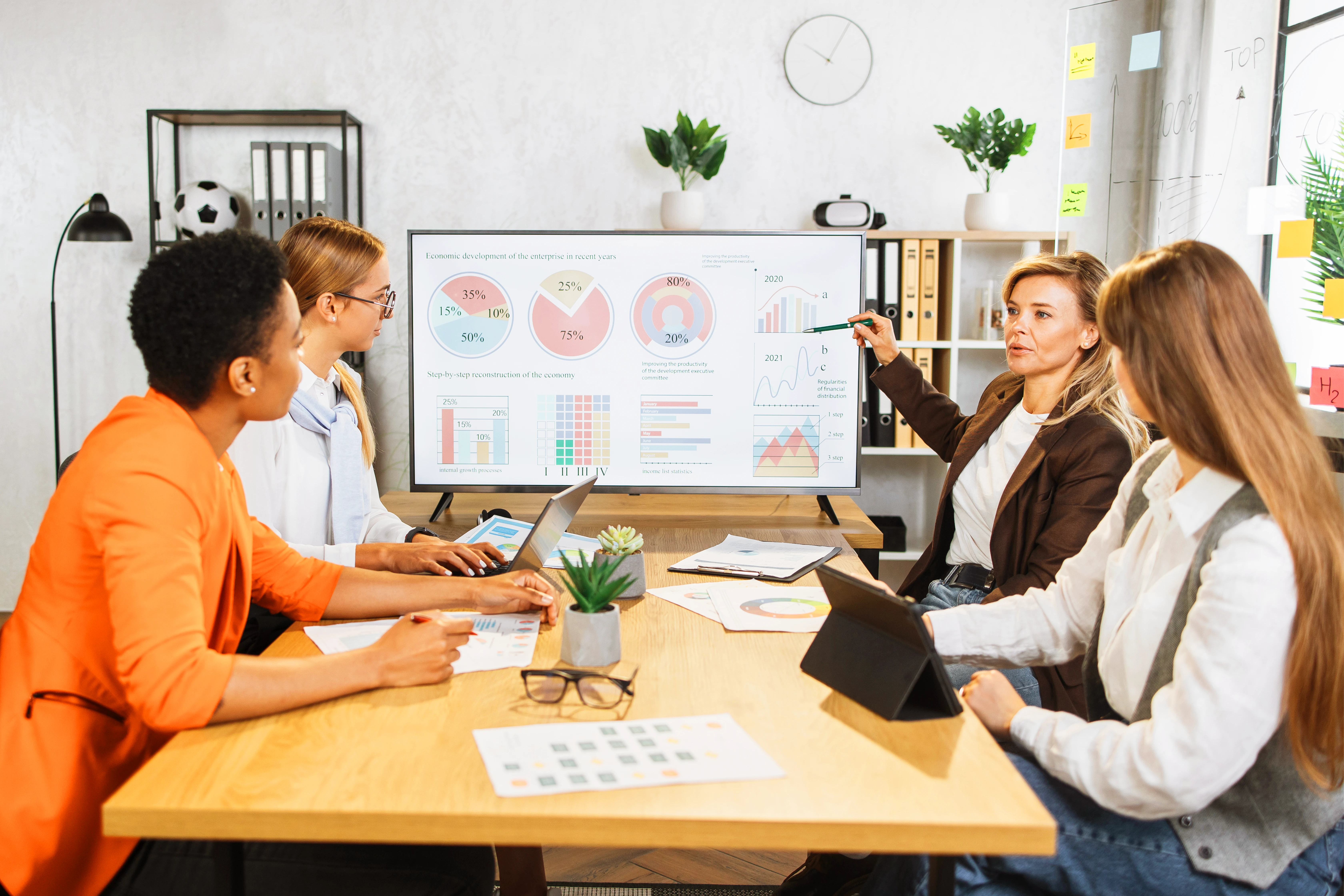 Group of professionals analyzing sales data on a screen during a comprehensive sales process assessment meeting