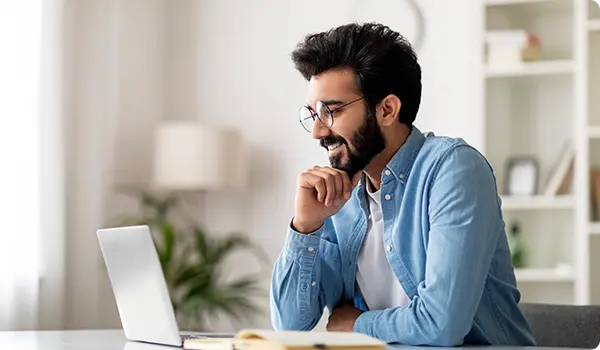 Man working on a laptop, illustrating Exigo Tech's AI Content Creator's customizable inputs for topic, audience, tone, and language to create tailored content.